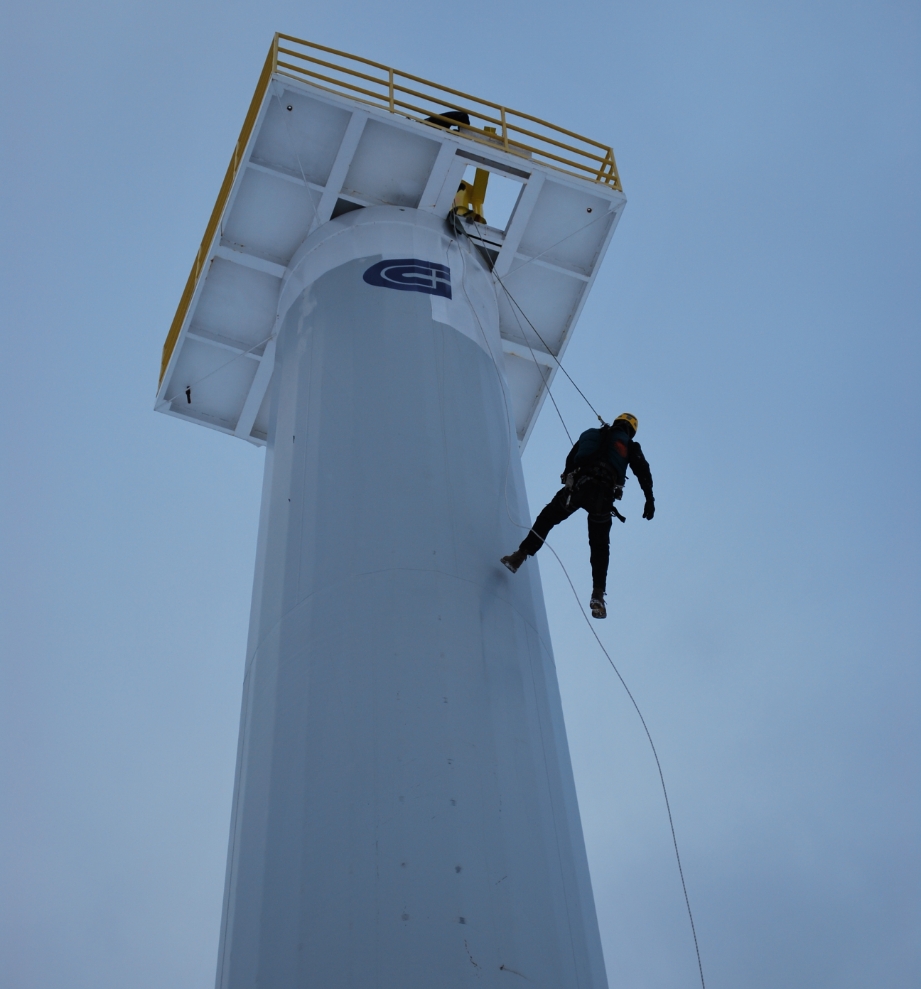 Technicien en rappel sur une structure industrielle en hauteur.